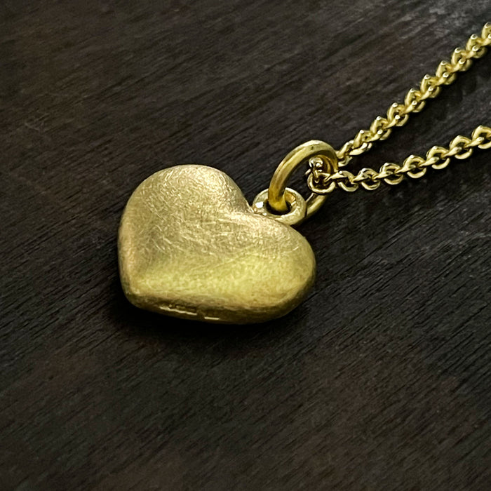 side photo of our solid 925 sterling silver heart pendant with a 24k gold vermeil finish showing the hallmark on the side of the pendant.