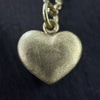 photo of our solid 925 sterling silver heart pendant with a 24k gold vermeil finish showing the texture on the pendant.