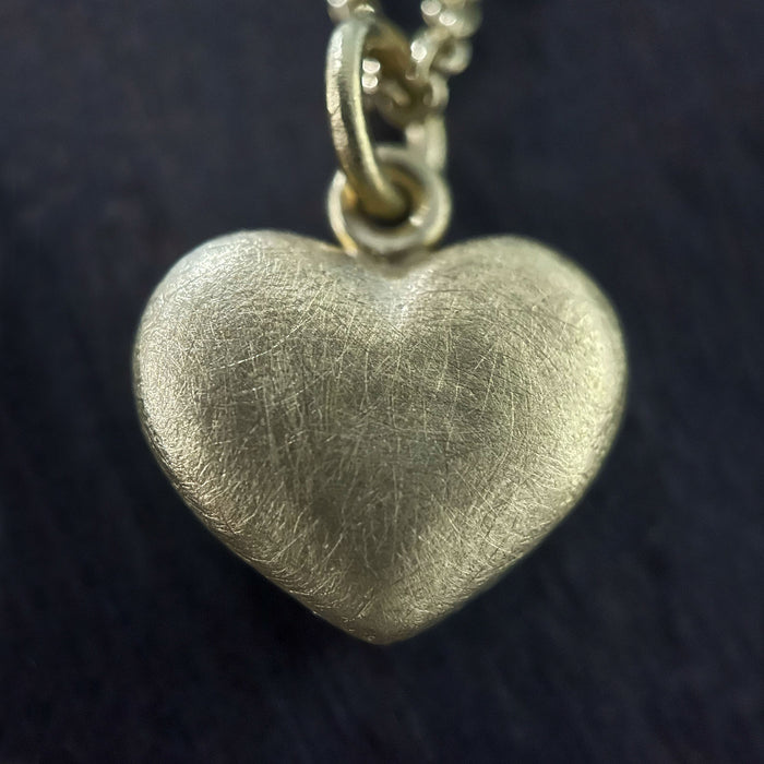 photo of our solid 925 sterling silver heart pendant with a 24k gold vermeil finish showing the texture on the pendant.