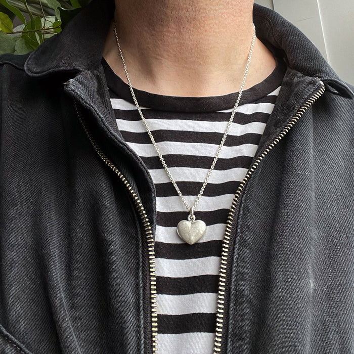 straight on photo of our Solid 925 Sterling Silver three dimensional heart pendant on a male model.