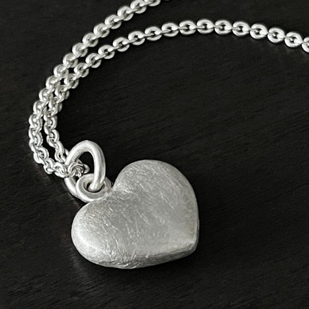 Solid 925 Sterling Silver three dimensional heart pendant shown on a trace chain.