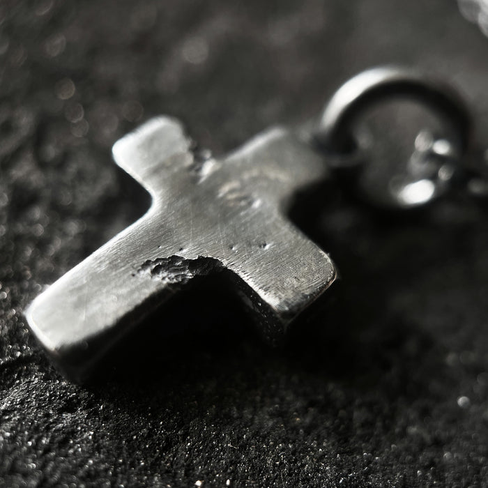 detail photo showing the texture on the rustic cross pendant.