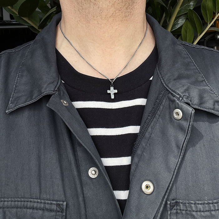 rustic cross pendant shown on a male model
