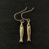 detail photo of gold sardine fish hook earrings made by jewel thief Brighton.